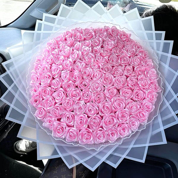 a huge bouquet of pink glitter roses inside a car