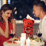 a man gifting the preserved rose bear box with jewelry inside to a woman who's sitting opposite him at a table